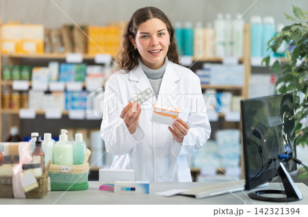 Young woman pharmacist offering pills Young woman pharmacist offering pills 142321394