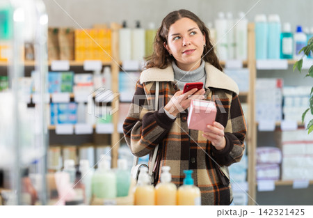 Young woman scanning qr code of pills 142321425