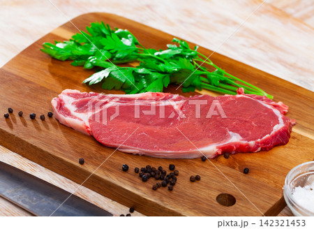 Sliced pieces of raw beef tenderloin on wooden cutting board 142321453