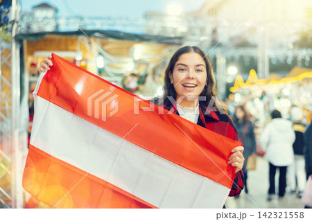 Happy girl with Austrian flag waving at New Year fair 142321558