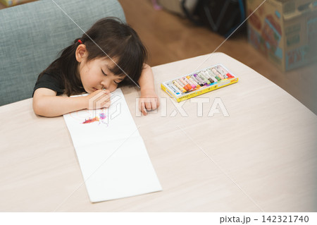 自宅で塗り絵をしながら寝てしまった3歳の女の子 自宅で塗り絵をしながら寝てしまった3歳の女の子 142321740