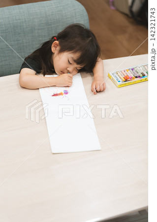 自宅で塗り絵をしながら寝てしまった3歳の女の子 自宅で塗り絵をしながら寝てしまった3歳の女の子 142321743