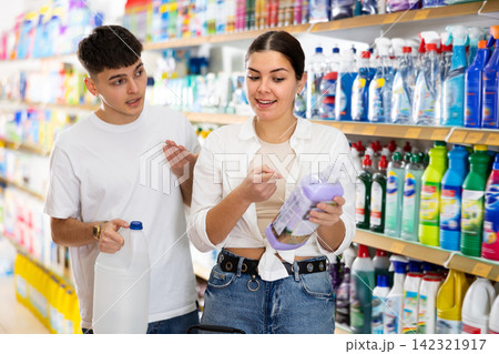 in shop,man and woman choose detergent for dishes. in shop,man and woman choose detergent for dishes. 142321917