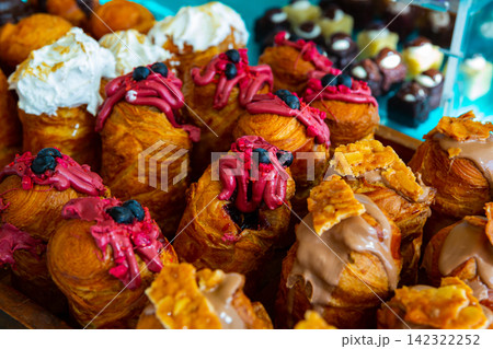 Assorted sweet cruffins topped with variety of creams 142322252