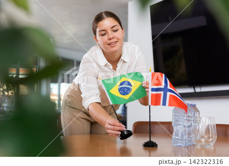 female assistant prepares conference room for diplomats of Norway and Brazil female assistant prepares conference room for diplomats of Norway and Brazil 142322316