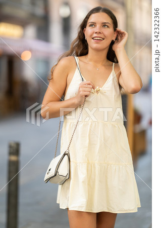 Young woman looks around at street cafes Young woman looks around at street cafes 142322366