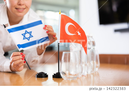 Little flag of Turkey on table and flag of Israel put next to it by young woman Little flag of Turkey on table and flag of Israel put next to it by young woman 142322383