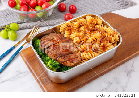 fusilli and spaghetti pasta bento boxes with steak sausages and fresh fruit 142322521