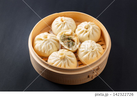 steamed pork buns with cilantro filling served in bamboo steamer 142322726