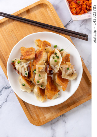 crisp pan fried dumplings guotie topped with chopped green onion crisp pan fried dumplings guotie topped with chopped green onion 142322785