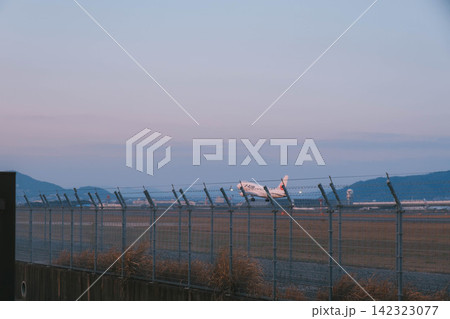 [伊丹スカイパーク]夕暮れ時の茜色の空へ！伊丹空港から飛び立つ飛行機！ 142323077
