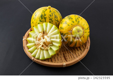 whole and Cut Striped Oriental Melon 142323595