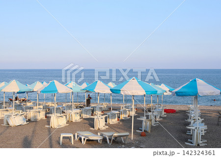Summer beach with umbrellas by the sea early in the morning 142324361