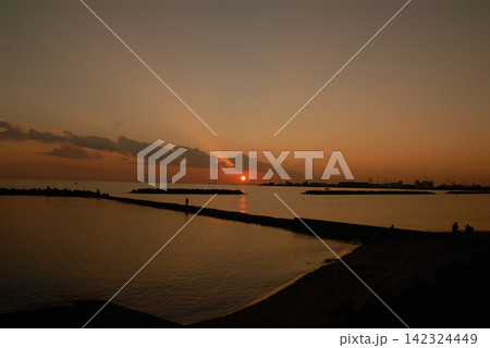 防波堤の夕日と港湾シルエット 142324449