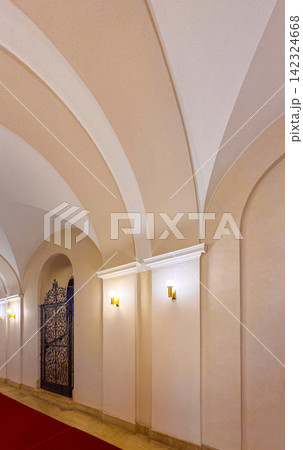 Architectural details of a hallway with arches and light fixtures 142324668