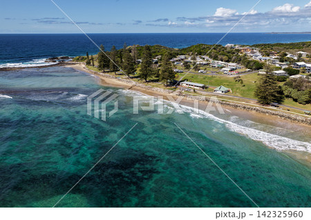 Aerial view of Brooms Head Beach and rocky headland, showing the sandy shoreline, Pacific Ocean, surrounding coastal landscape and township of Brooms Head along the Clarence Valley coast of NSW, Aerial view of Brooms Head Beach and rocky headland, showing the sandy shoreline, Pacific Ocean, surrounding coastal landscape and township of Brooms Head along the Clarence Valley coast of NSW, 142325960