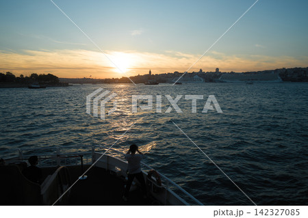 トルコ・イスタンブール、フェリーの舳先から夕景を眺める人物のシルエット 142327085