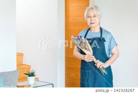 ドライフラワーを趣味にする花束を持つシニア女性 ドライフラワーを趣味にする花束を持つシニア女性 142328267