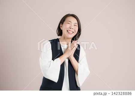 ピンク背景で目標達成を喜び笑顔で感謝するありがとうポーズ 喜ぶを表現する40代女性のポートレート ピンク背景で目標達成を喜び笑顔で感謝するありがとうポーズ 喜ぶを表現する40代女性のポートレート 142328886