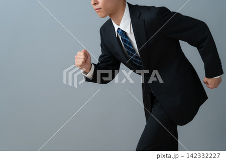 グレー背景の若いビジネスマン グレー背景の若いビジネスマン 142332227