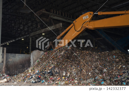 Massive plastic waste pile under a conveyor belt at a recycling plant, waste sorting, recycling, sustainability, circular economy, and environmental protection. Massive plastic waste pile under a conveyor belt at a recycling plant, waste sorting, recycling, sustainability, circular economy, and environmental protection. 142332377