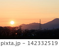 桜並木と山並みに沈む夕日 送電塔が立つ岐阜県大垣市墨俣の春夕景 142332519