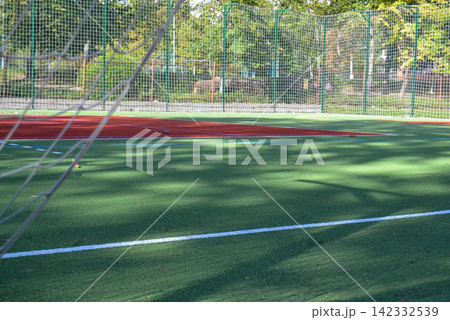 School soccer stadium. Empty soccer field behind the iron fence. High quality photo School soccer stadium. Empty soccer field behind the iron fence. High quality photo 142332539