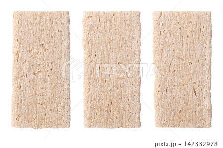 Slices of rye crispy bread, side by side, isolated from above. Group of 3 rectangular crispbread slices in a row, flat, dry and crisp crackers, made from whole grain rye flower, water and salt. Photo 142332978