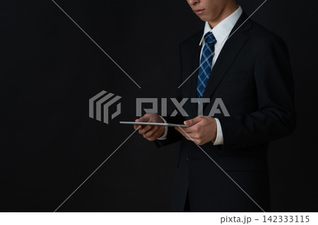 黒背景の若いビジネスマン 142333115