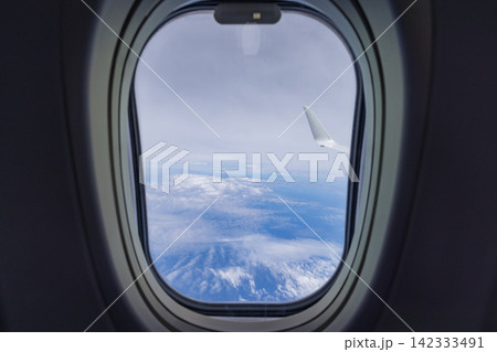 日本　沖縄上空を飛ぶ旅客機の窓から見た青空と海と雲海 142333491