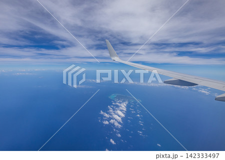 日本 沖縄上空を飛ぶ旅客機の窓から見た与論島と青空と海 日本 沖縄上空を飛ぶ旅客機の窓から見た与論島と青空と海 142333497