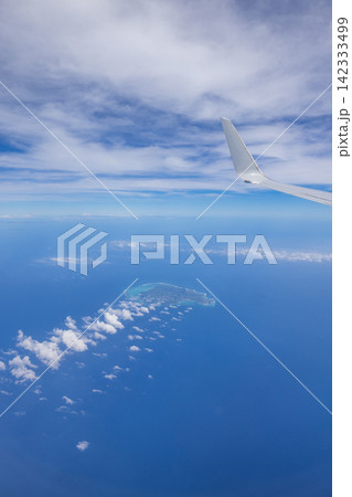 日本　沖縄上空を飛ぶ旅客機の窓から見た与論島と青空と海 142333499