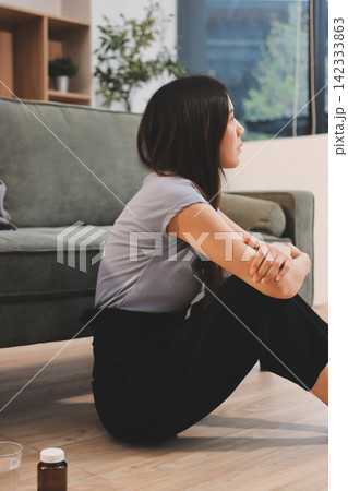 Young Asian woman sitting in bed and holding her head in pain with headache, feeling depressed and suffering Young Asian woman sitting in bed and holding her head in pain with headache, feeling depressed and suffering 142333863