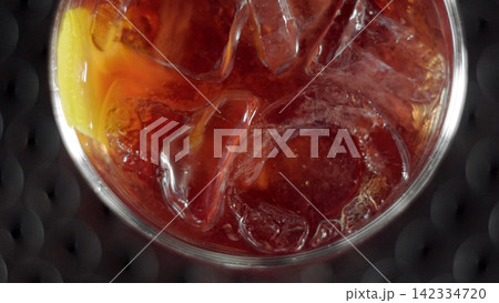 Negroni cocktail with ice cubes and orange peel close-up, enjoying refreshing aperitif drink Negroni cocktail with ice cubes and orange peel close-up, enjoying refreshing aperitif drink 142334720