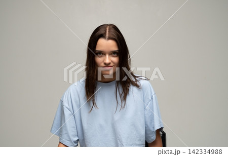 Confident brunette woman giving a subtle smirk, looking powerful and self-assured in studio portrait, expressing determination Confident brunette woman giving a subtle smirk, looking powerful and self-assured in studio portrait, expressing determination 142334988