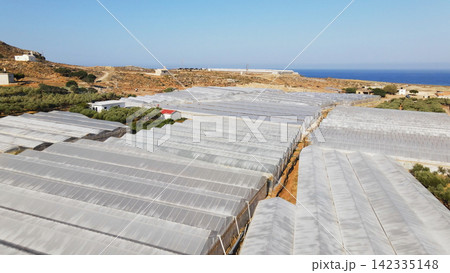 Extensive greenhouse farming operations in arid coastal landscape, Crete, Greece, providing agricultural production 142335148