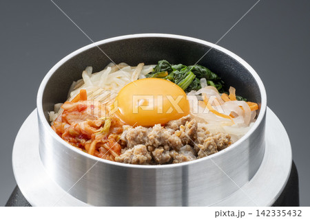 釜で作る韓国料理ビビンバ、黄色い卵と挽き肉、野菜を盛った一杯 釜で作る韓国料理ビビンバ、黄色い卵と挽き肉、野菜を盛った一杯 142335432