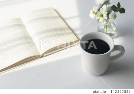 朝の光の中のコーヒーと本、花のある穏やかな時間 朝の光の中のコーヒーと本、花のある穏やかな時間 142335825