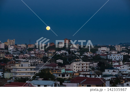 Moonrise in night sky. Full moon shines at night over small town in Balkans 142335987
