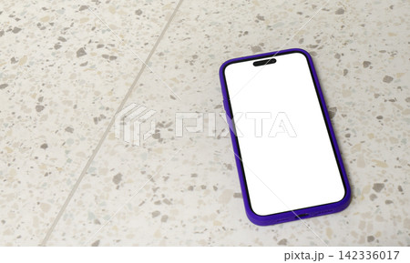 A smartphone with a blank white screen lies diagonally on a terrazzo tile floor, photographed from A smartphone with a blank white screen lies diagonally on a terrazzo tile floor, photographed from 142336017