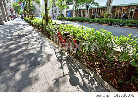午後の日差しを浴びる日本橋江戸桜通りに置かれた自転車 142336979