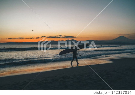 湘南の海に沈む夕日とサーファー 142337014