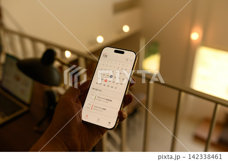 スマートフォンでカレンダーを確認する手 スマートフォンでカレンダーを確認する手 142338461
