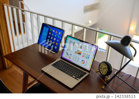 デスク上のノートパソコンとタブレット、目覚まし時計 デスク上のノートパソコンとタブレット、目覚まし時計 142338513