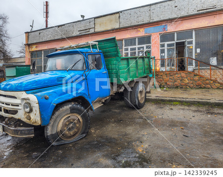 Weathered Blue Flatbed Truck with Flat Tire in Kyrgyzstan Weathered Blue Flatbed Truck with Flat Tire in Kyrgyzstan 142339245