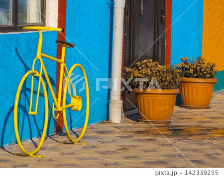 Bright Yellow Bicycle Sculpture in Colorful Urban Setting Bright Yellow Bicycle Sculpture in Colorful Urban Setting 142339255
