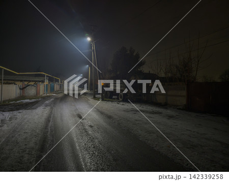 Deserted Rural Road at Night with Street Lamps and Truck 142339258