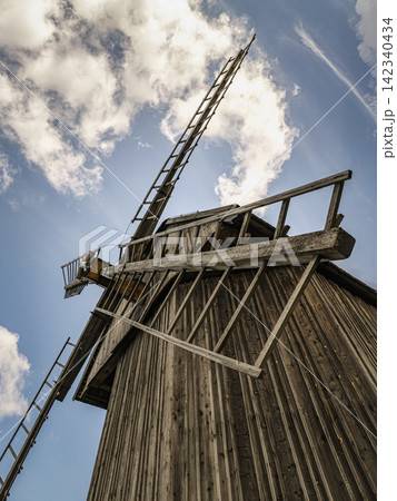 Rustic Wooden Windmill With Sunlit Sails Against A Clear Blue Sky In Countryside Rustic Wooden Windmill With Sunlit Sails Against A Clear Blue Sky In Countryside 142340434