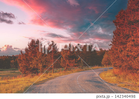 Rural landscape. Winding country road in the evening at sunset light 142340498