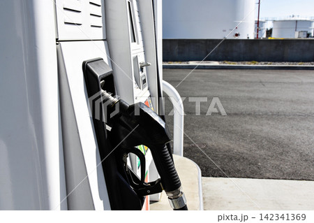 Close-up of a gas pump nozzle ready for fueling at a station Close-up of a gas pump nozzle ready for fueling at a station 142341369